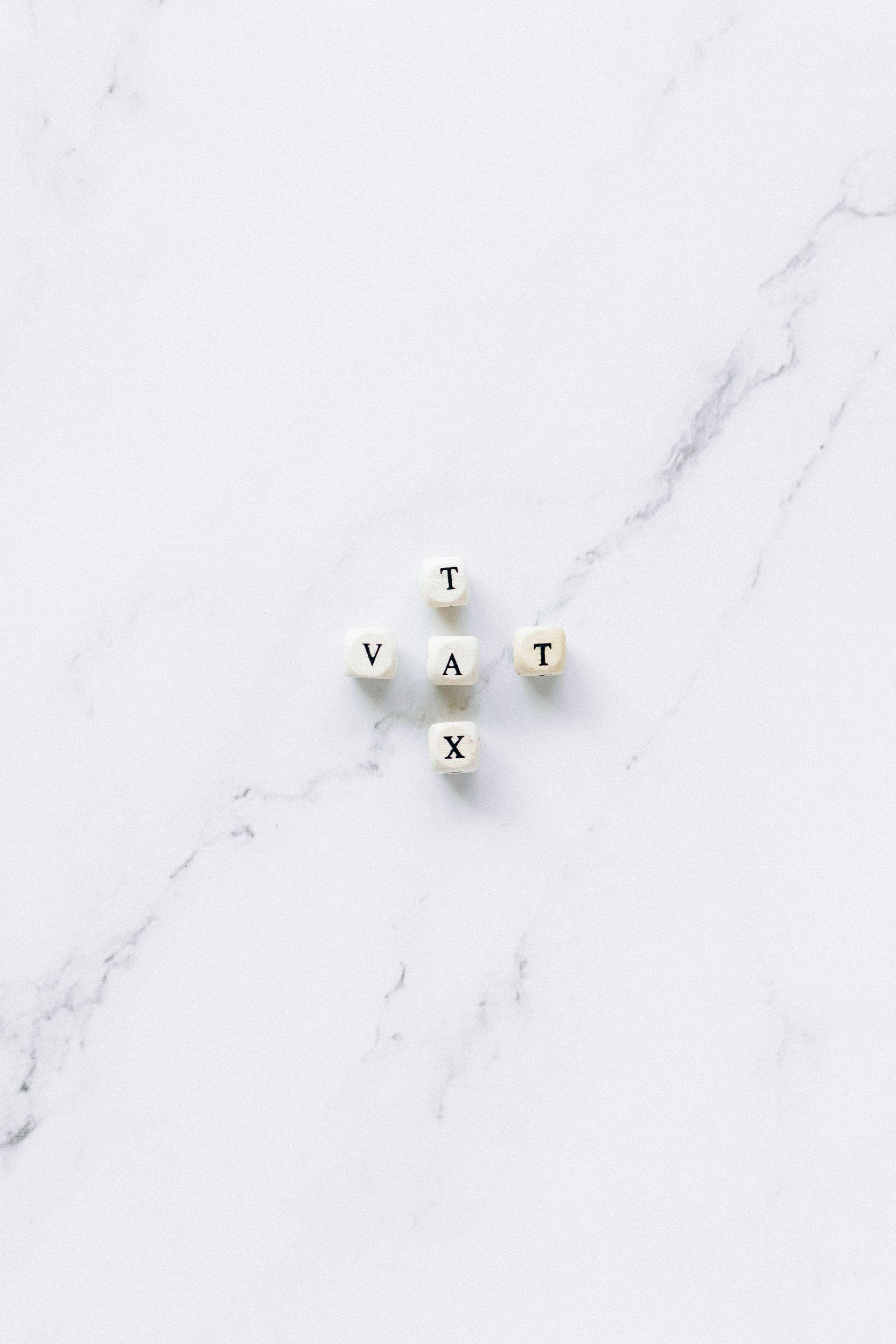 5 dice in a cross spelling VAT left to right and TAX top to bottom