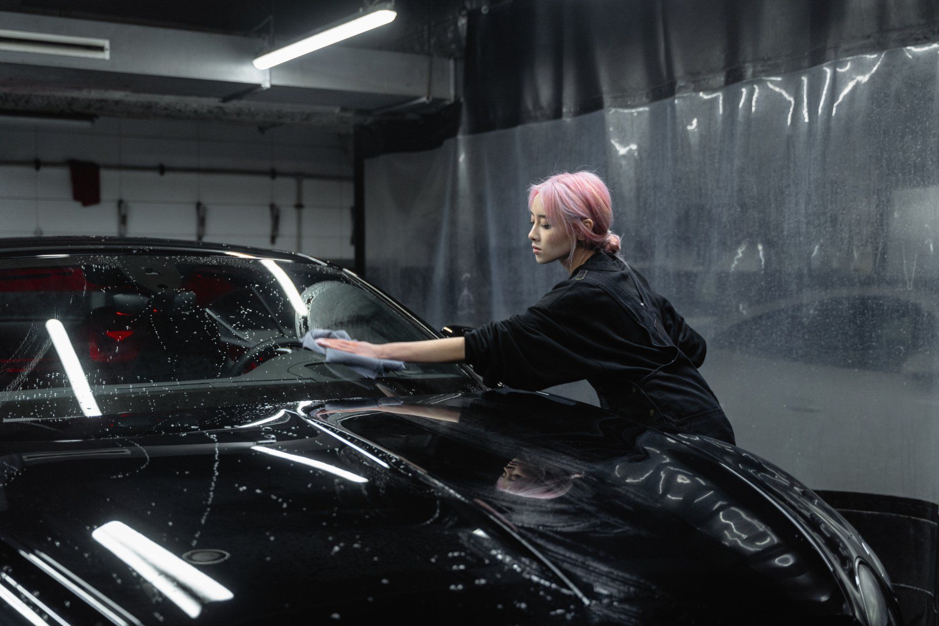 a woman wiping a car clean