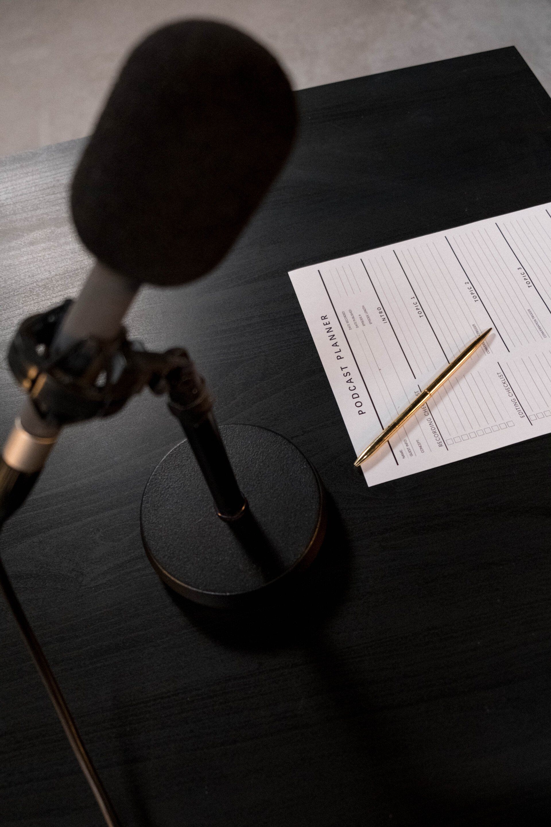 Audit process: a microphone is sitting on a table next to a pen