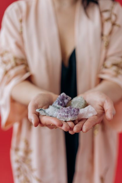 A woman is holding a pile of crystals in her hands.