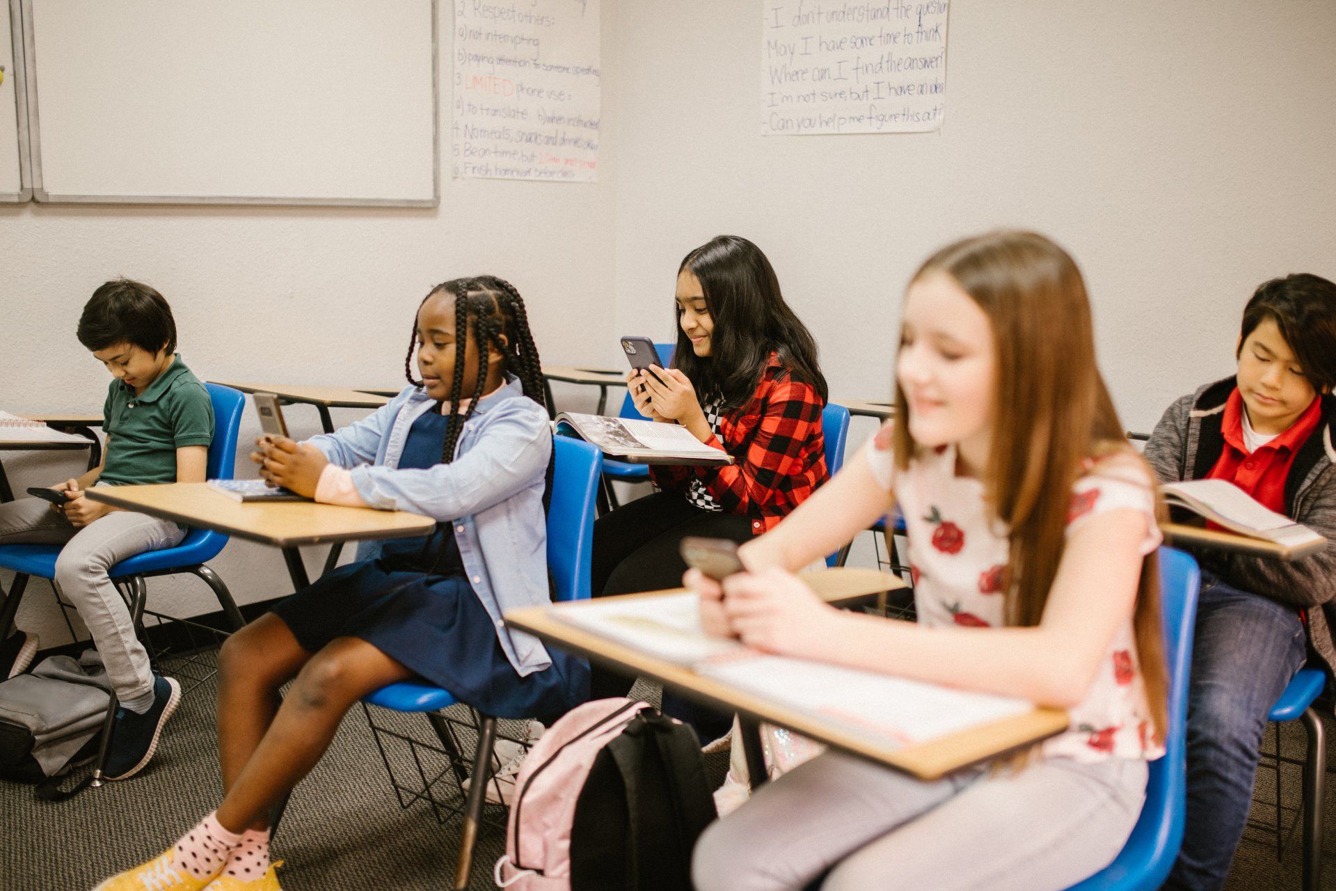 a group of children are sitting at desks in a classroom .