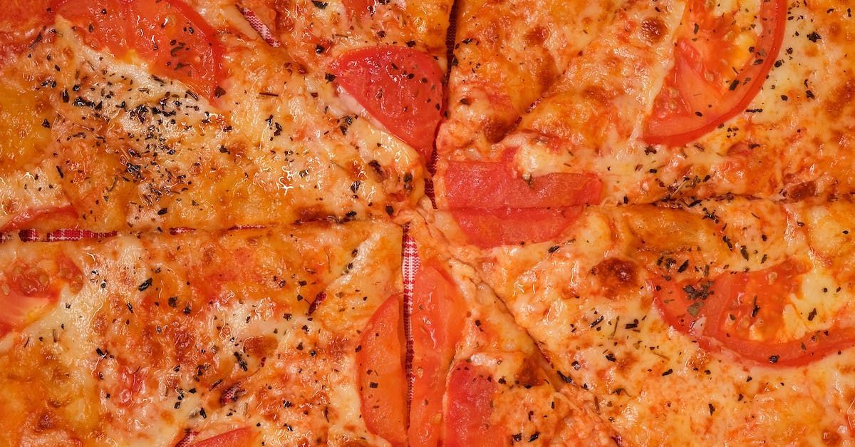 A close up of a pizza with tomatoes and cheese on a table.