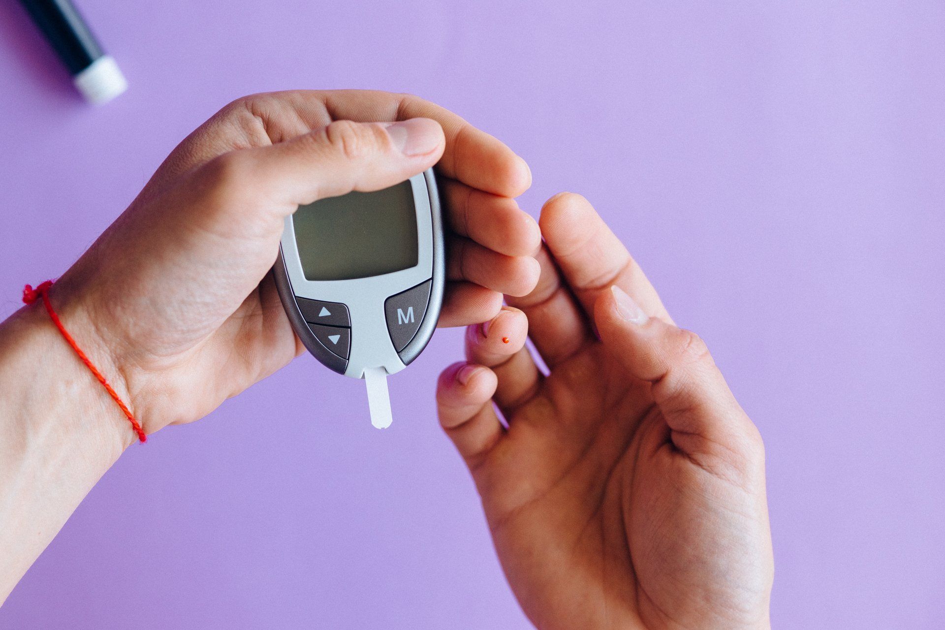 a glucose meeter in the hands of a diabetic person
