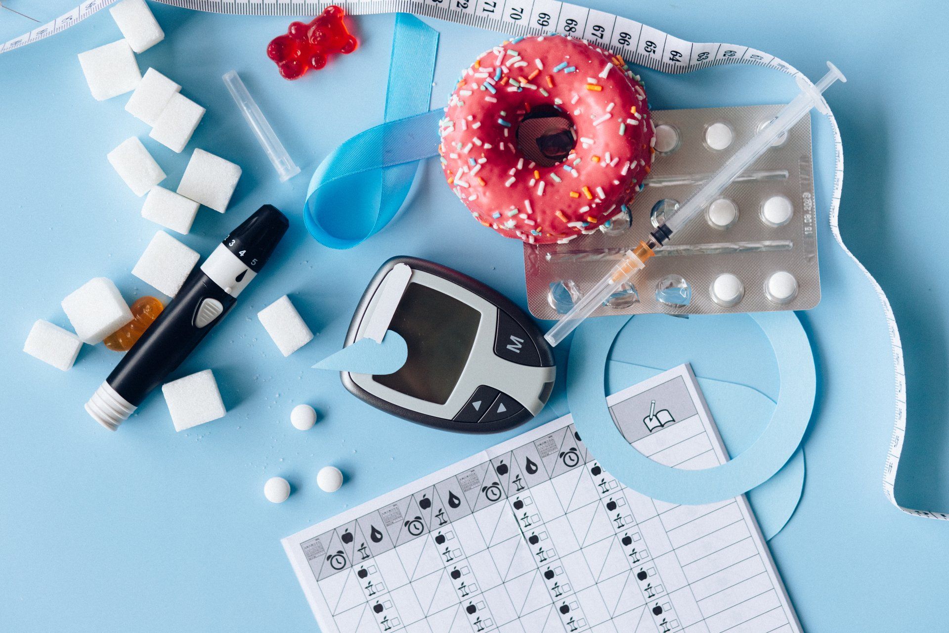 weight loss drugs, donut, glucose meter, and tape measure