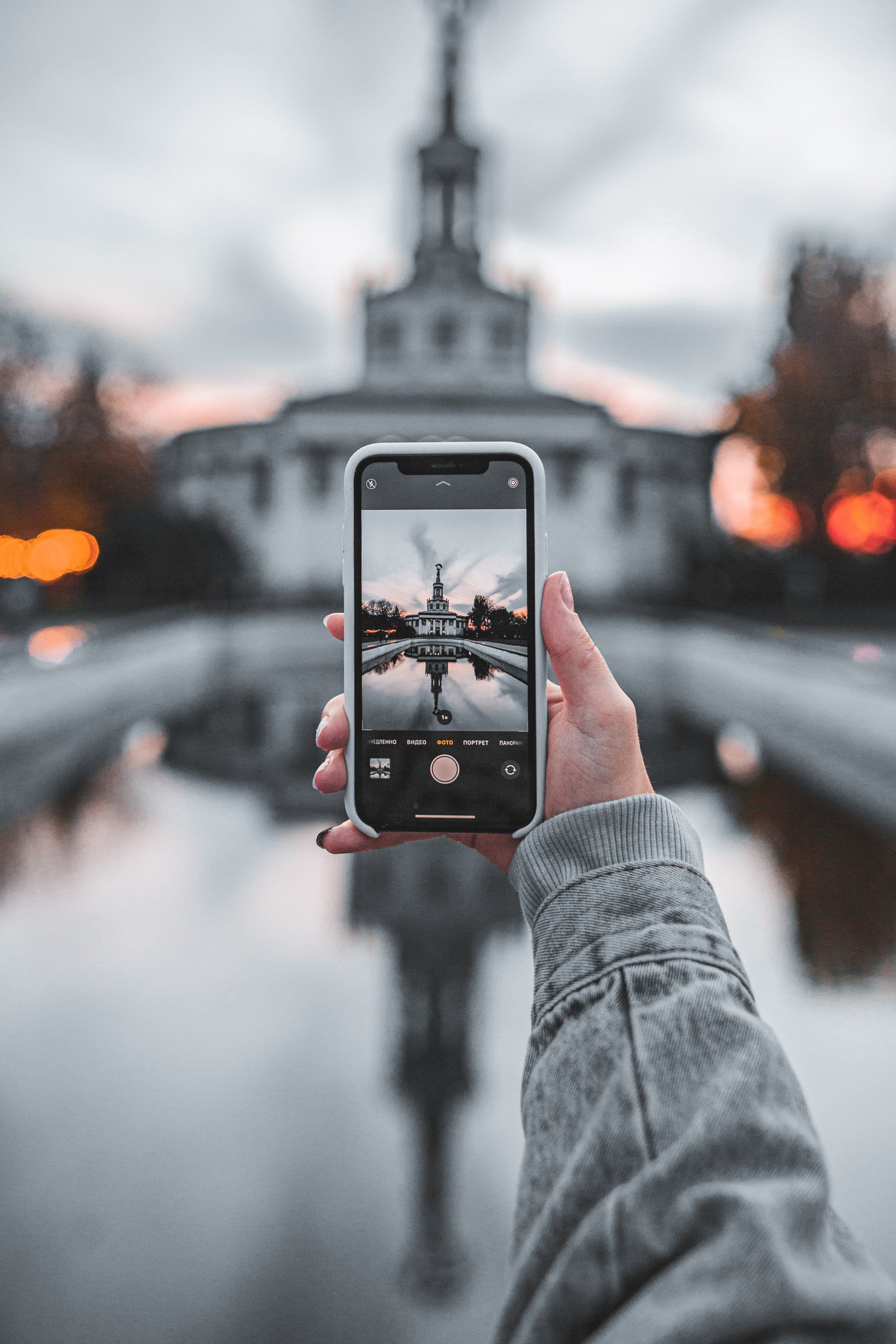 A person is taking a picture of a building with a cell phone