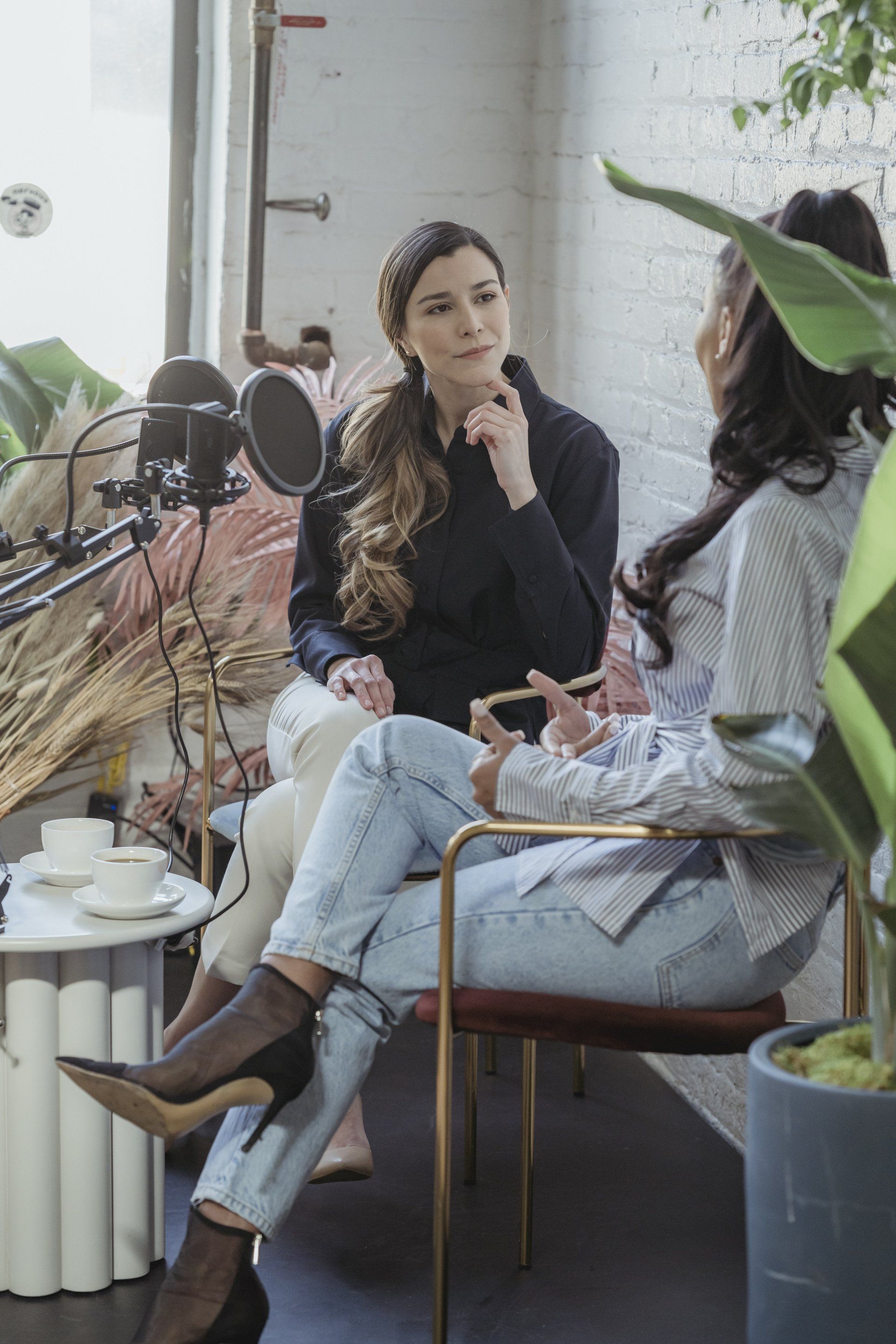 A group of women are sitting in chairs talking to each other in a room.