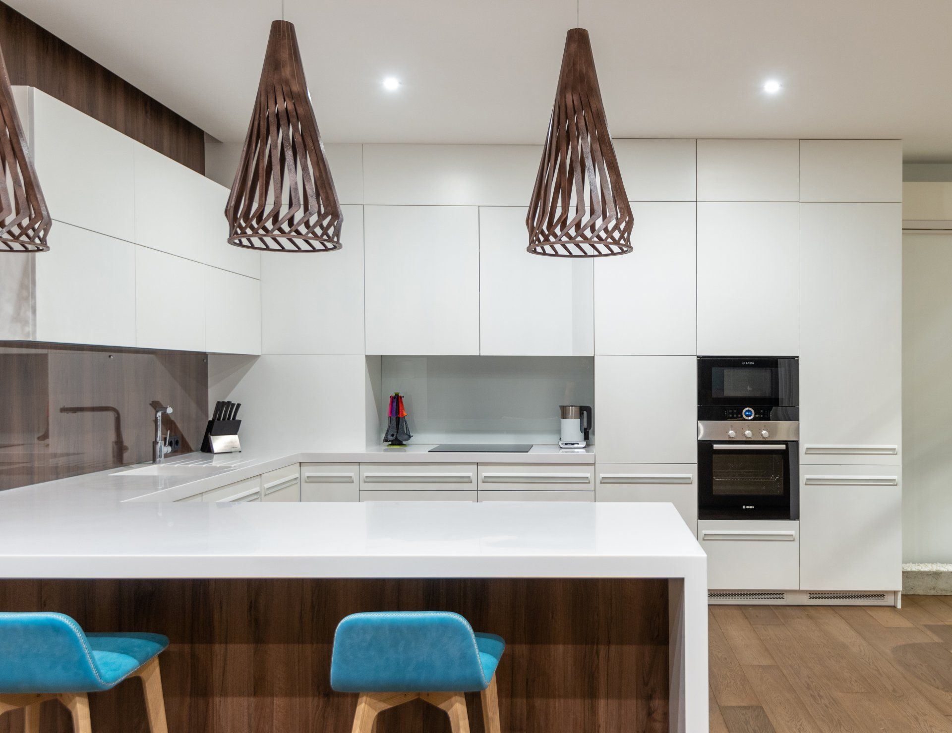 A kitchen with white cabinets and blue stools
