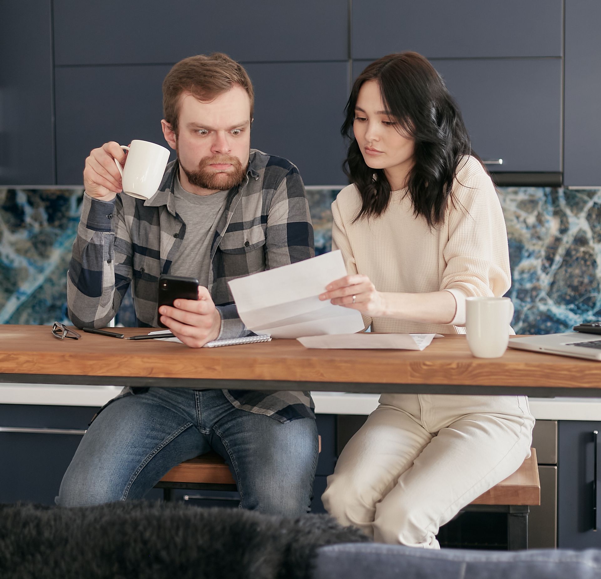 A man and a woman are sitting at a table looking at papers.