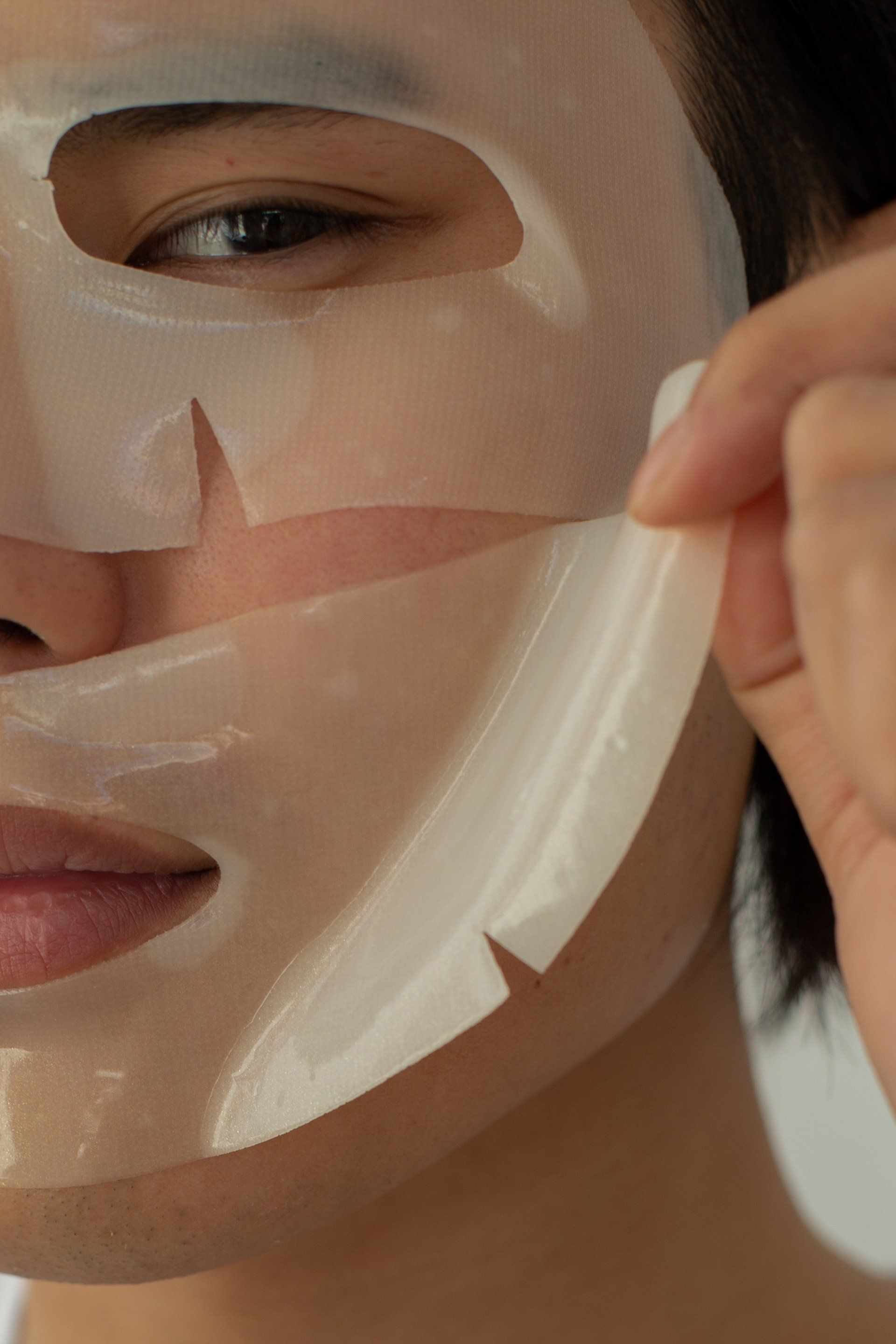A close up of a person wearing a sheet mask on their face.