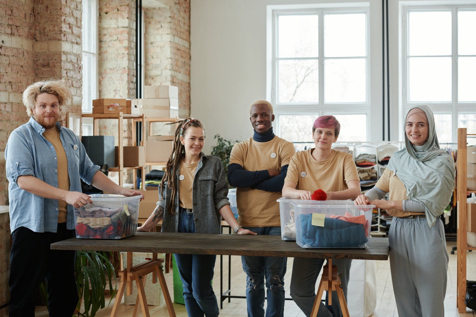 Five diverse employees standing in a warehouse. Non-profit organizations benefit greatly from highly effective HR initiatives.