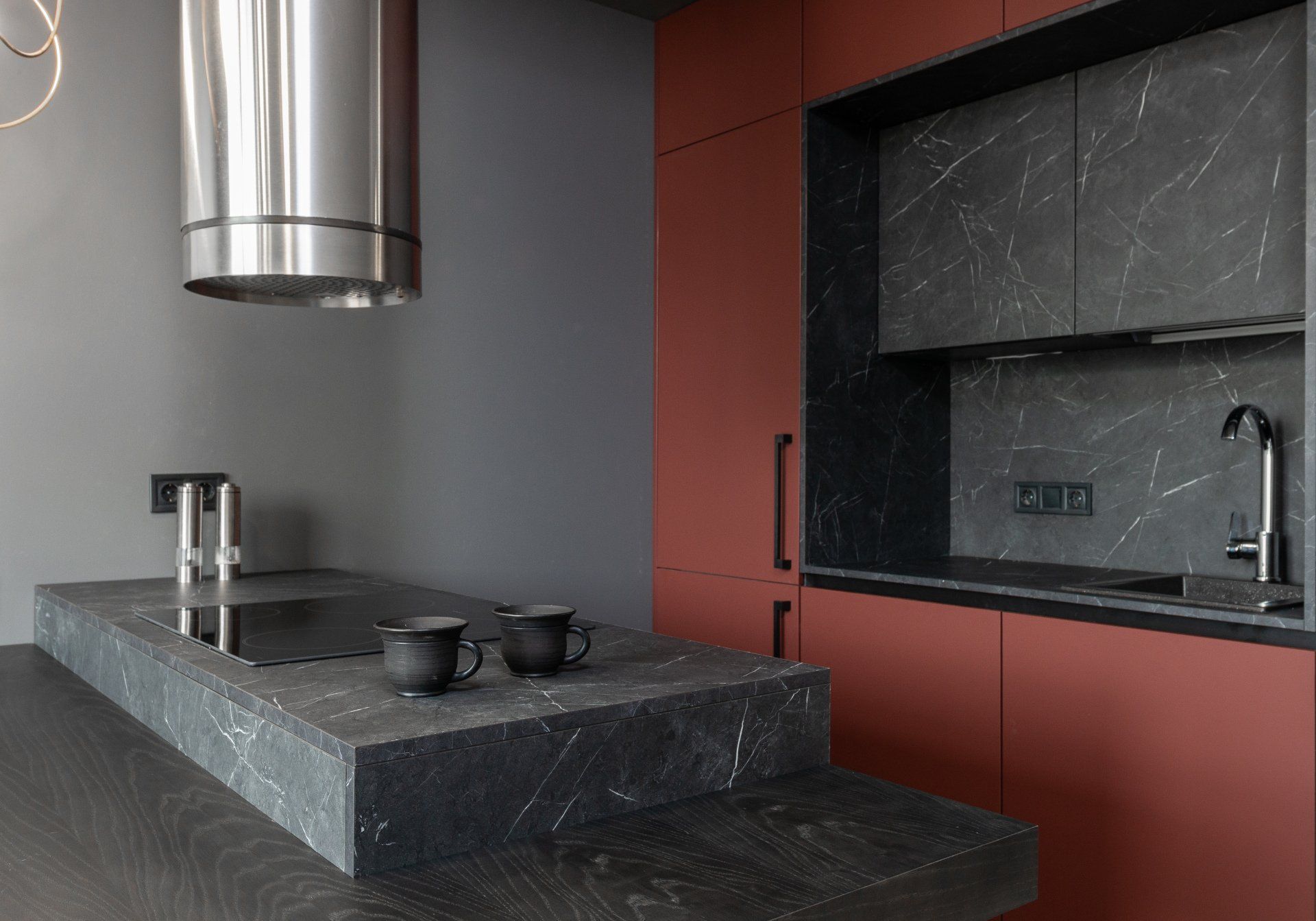 Black countertop with red cabinets in a luxury Chicago apartment