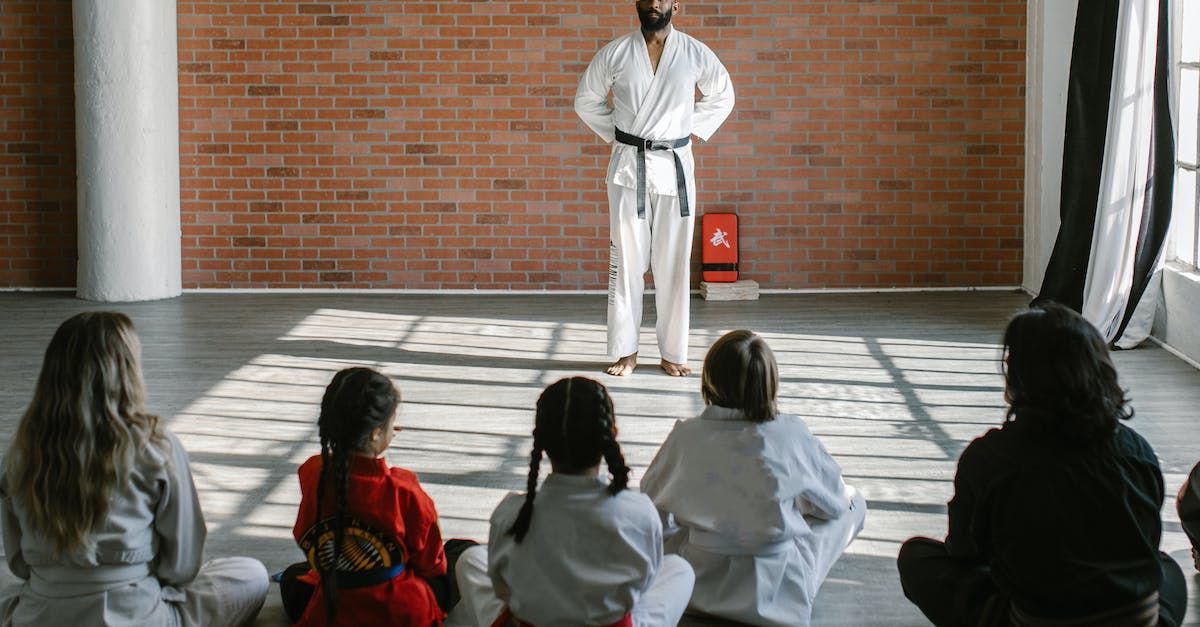 A group of people are watching a karate class in a gym.