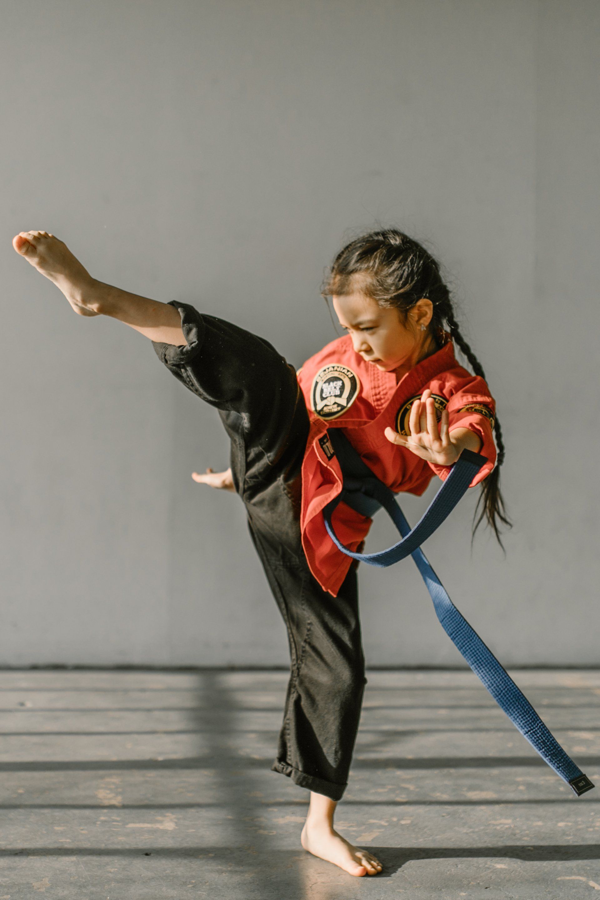 Een jong meisje beoefent karate met een blauwe band.
