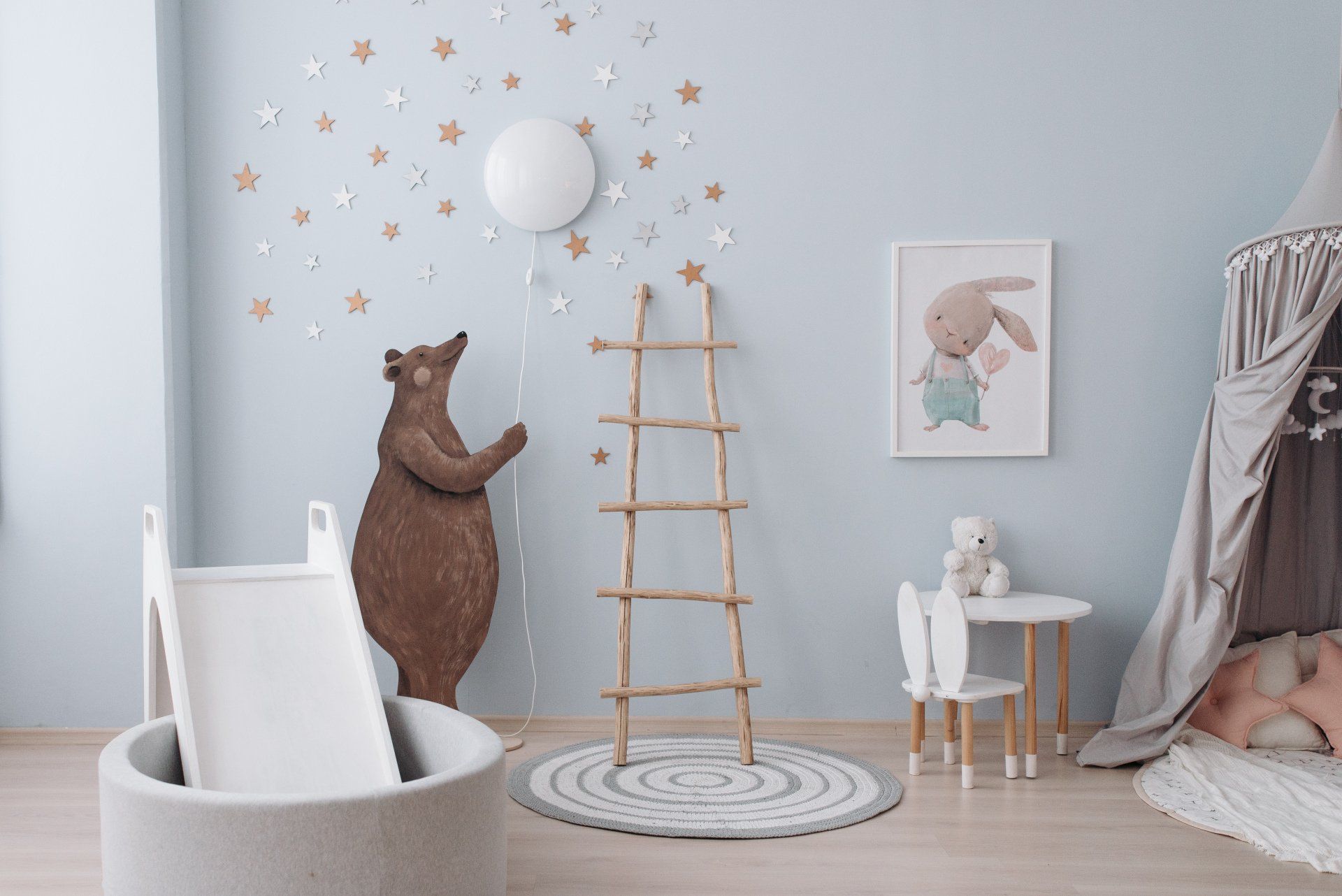 Neutral colored nursery  with stars on wall and big toy bear