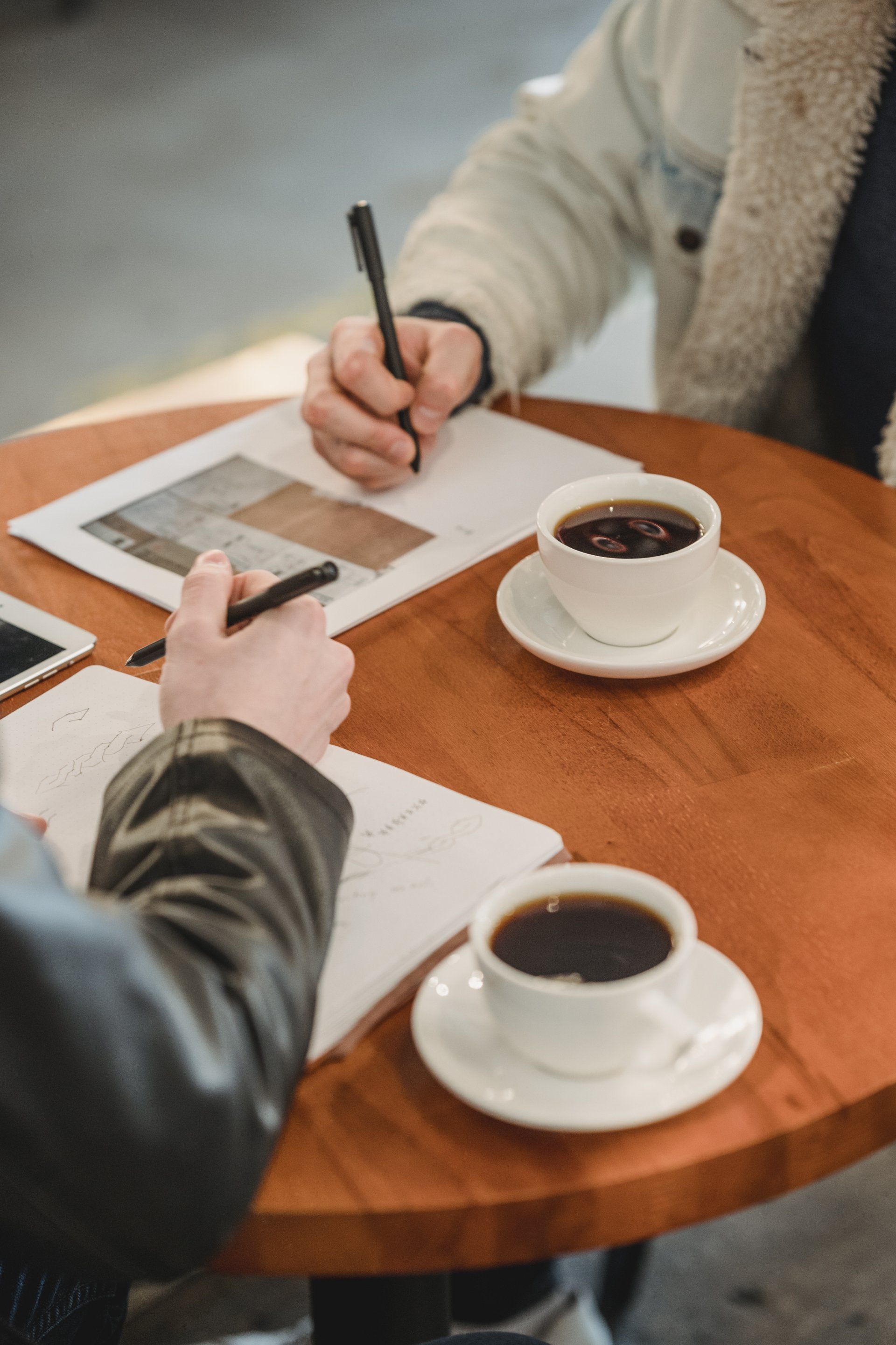 Dos personas están sentadas en una mesa con tazas de café.
