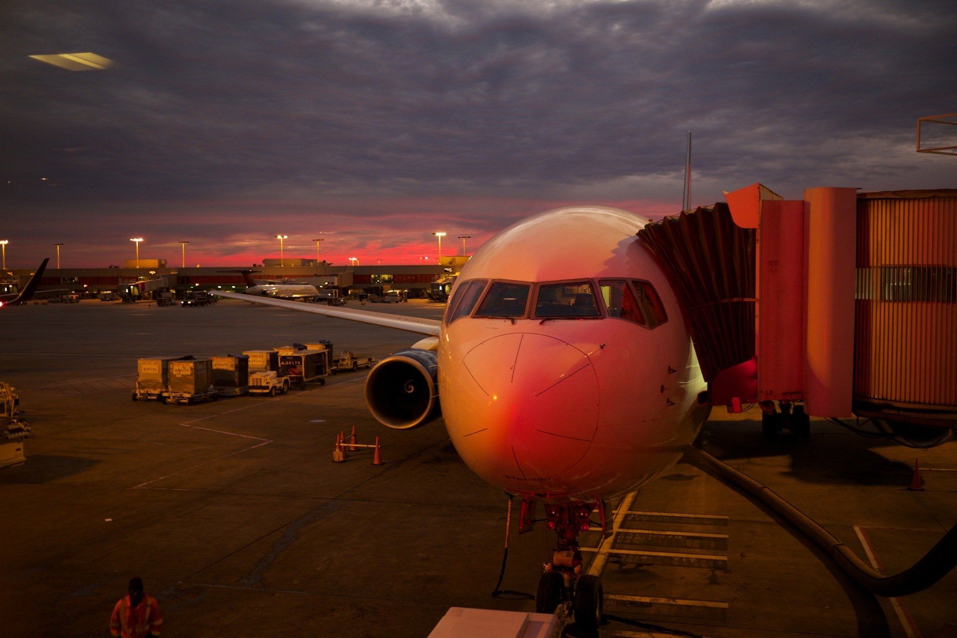 An airplane is parked at an airport at sunset