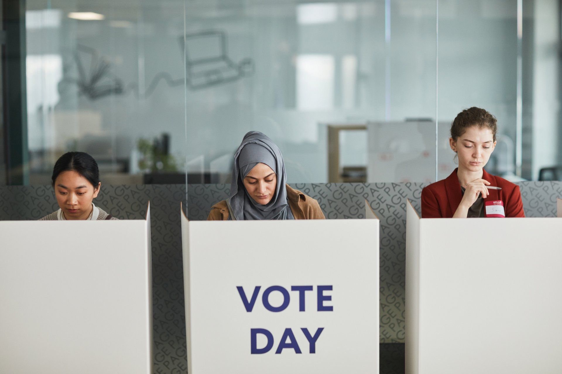 Three women voting in the general election in ballot boxes