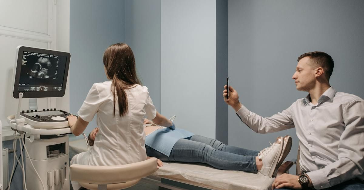 A man is taking a picture of a woman getting an ultrasound.