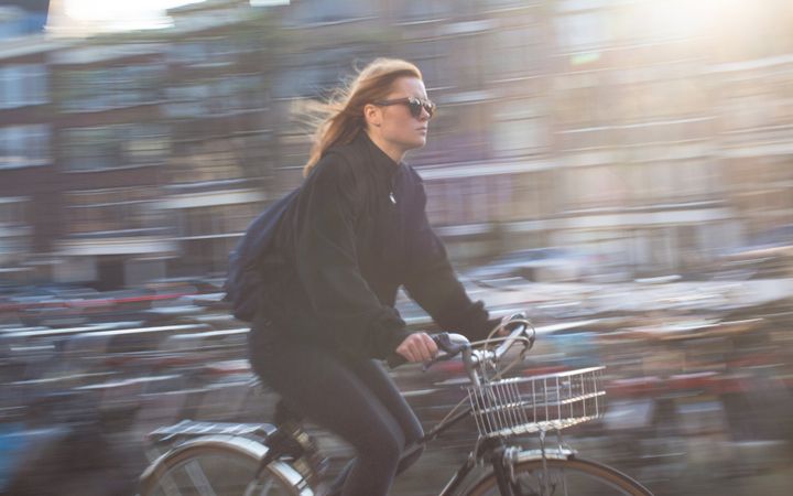a woman wearing sunglasses is riding a bike