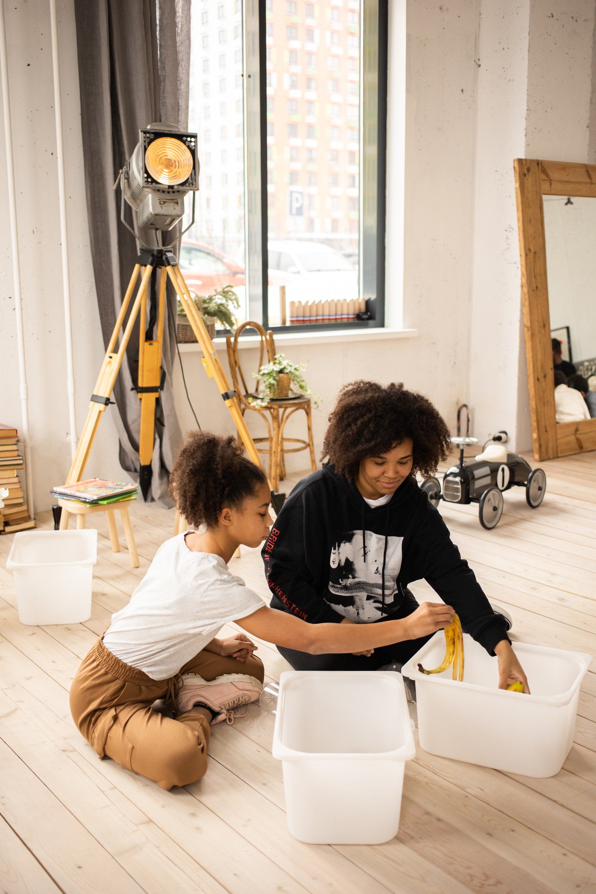 A woman and a child are sitting on the floor in a living room.