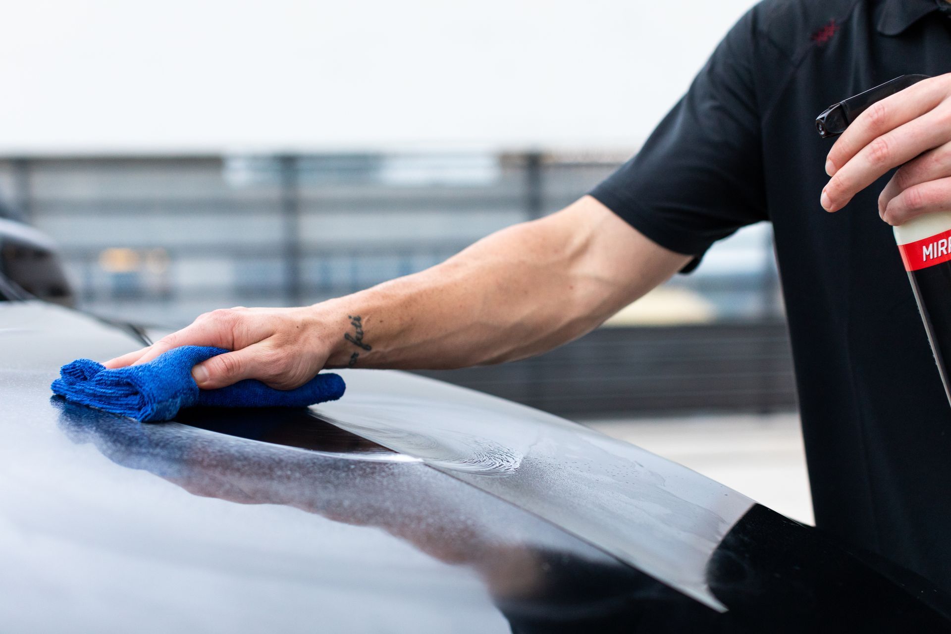 a person wiping a car's exterior