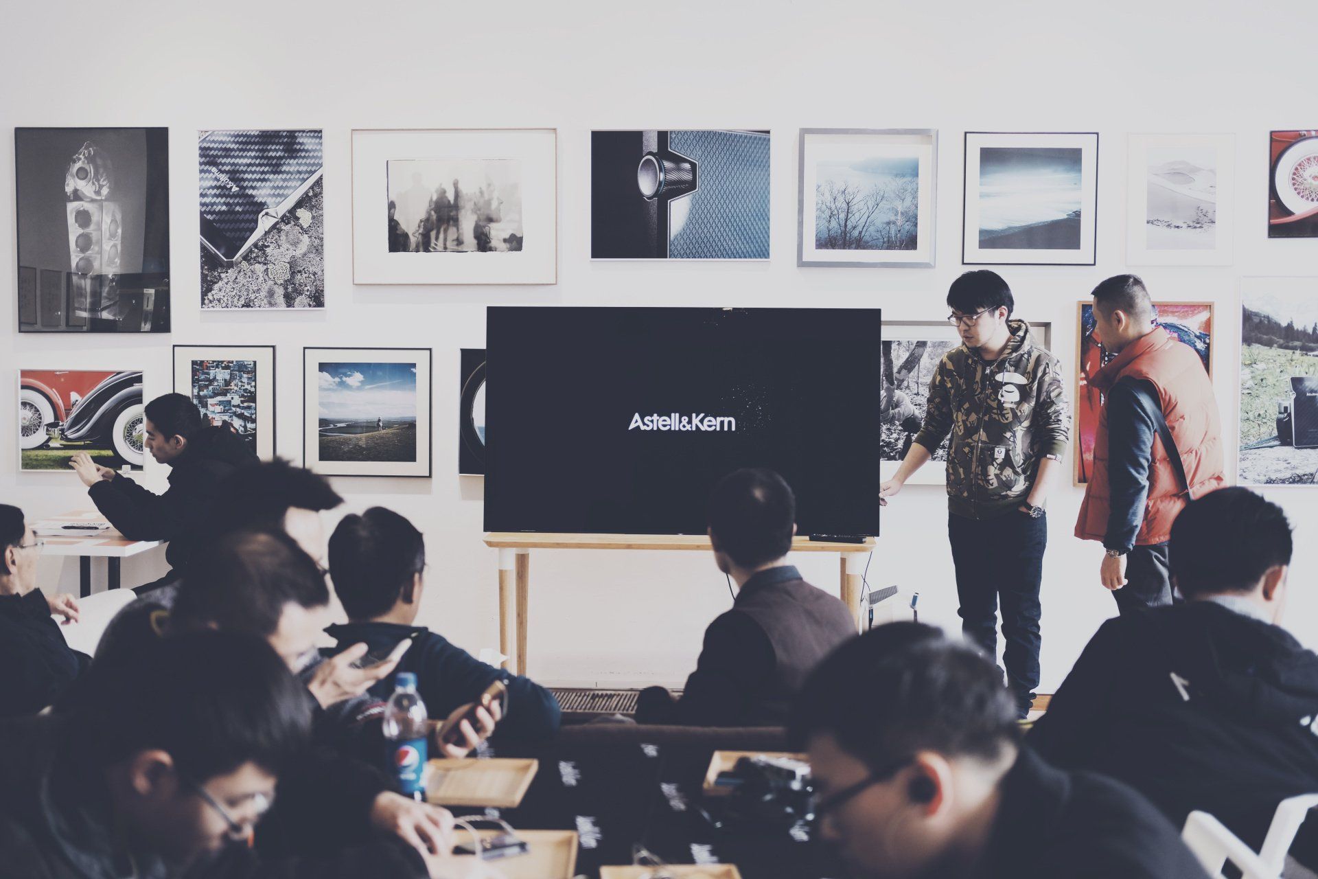 A group of people are sitting in front of a large screen.