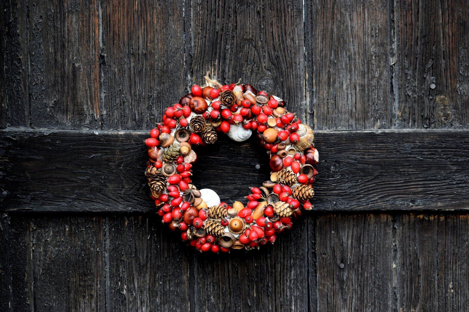 a christmas wreath is hanging on a wooden door