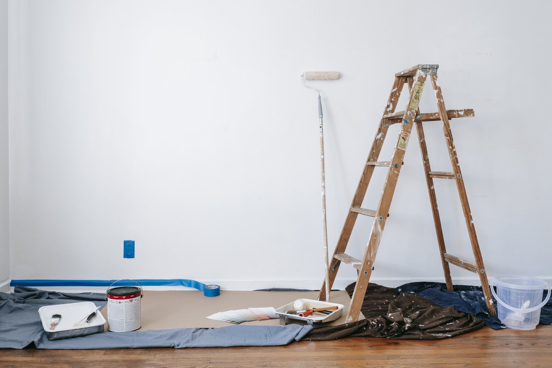 Home improvement equipment, such as a paint roller and ladder, in a room that is under renovation