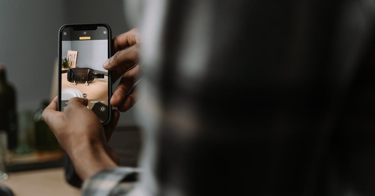 A person is taking a picture of a living room with a cell phone.