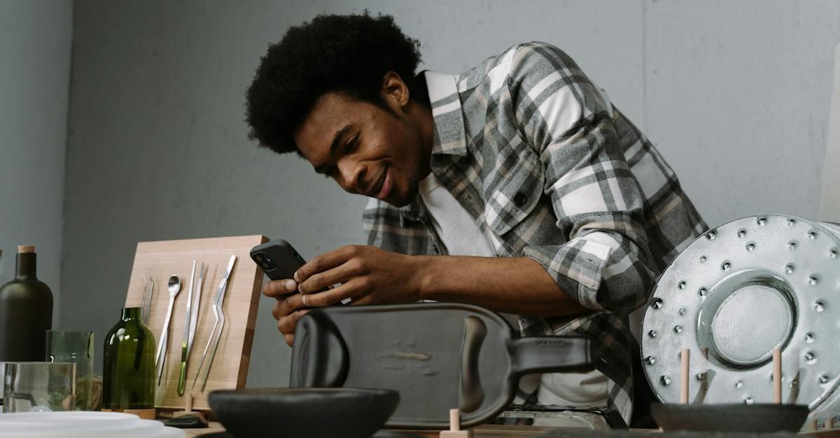 A man is sitting at a table working on a toaster oven.