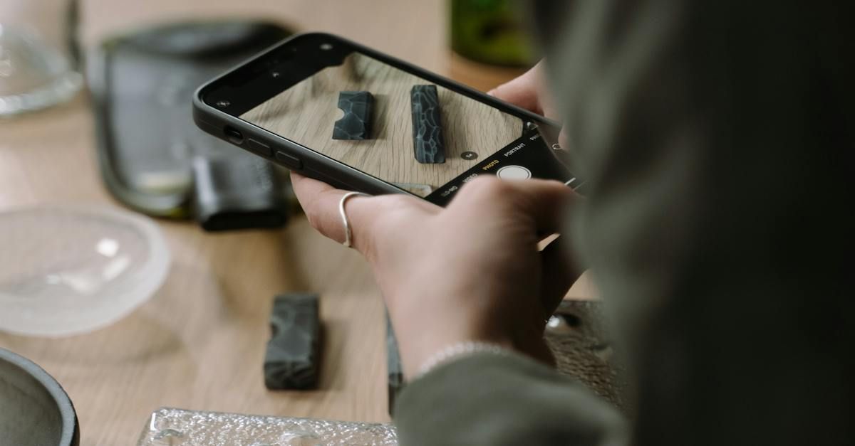 A person is taking a picture of a piece of wood with a cell phone.
