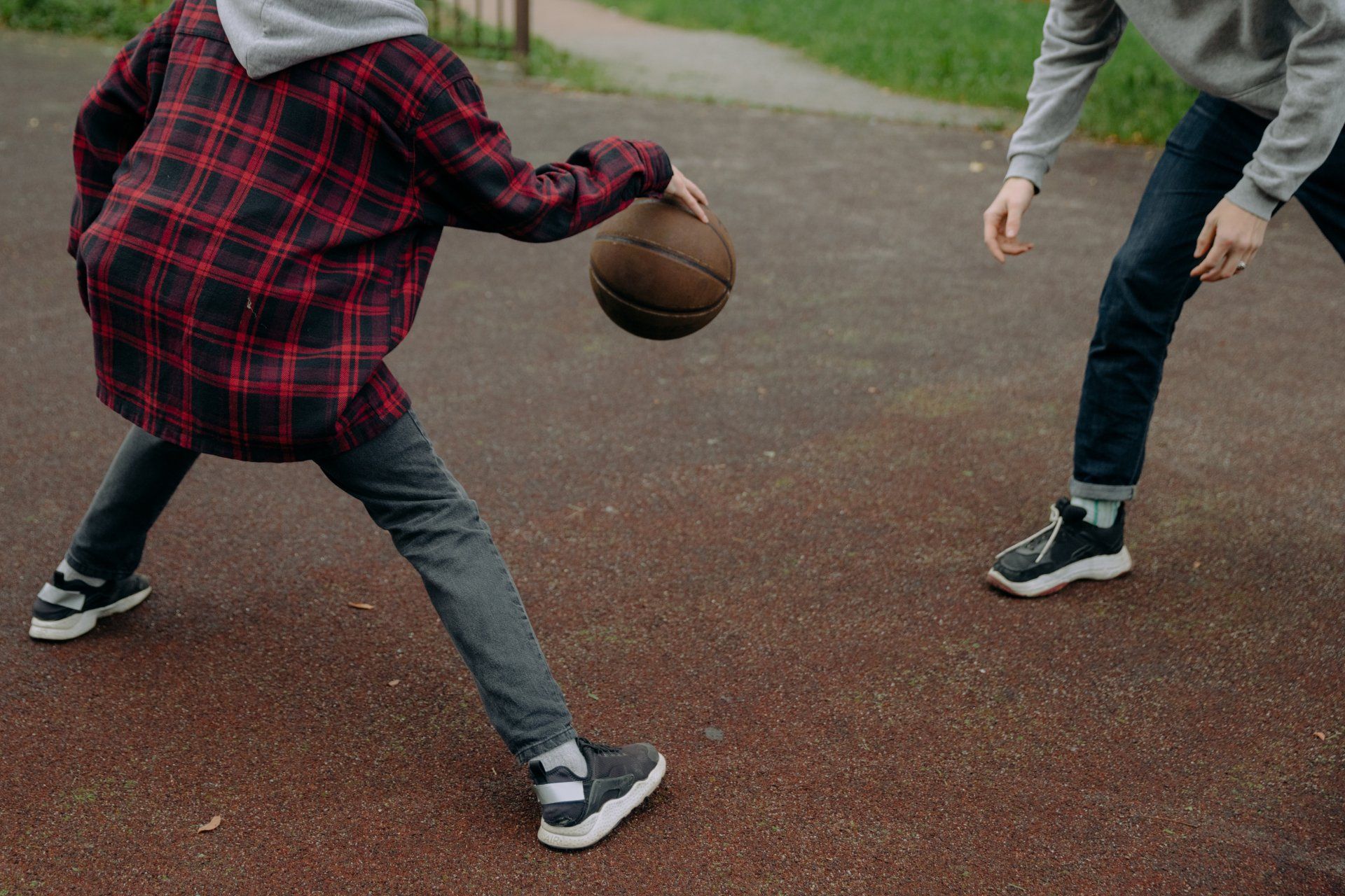 Ein Mann und ein Junge spielen Basketball auf einem Platz.