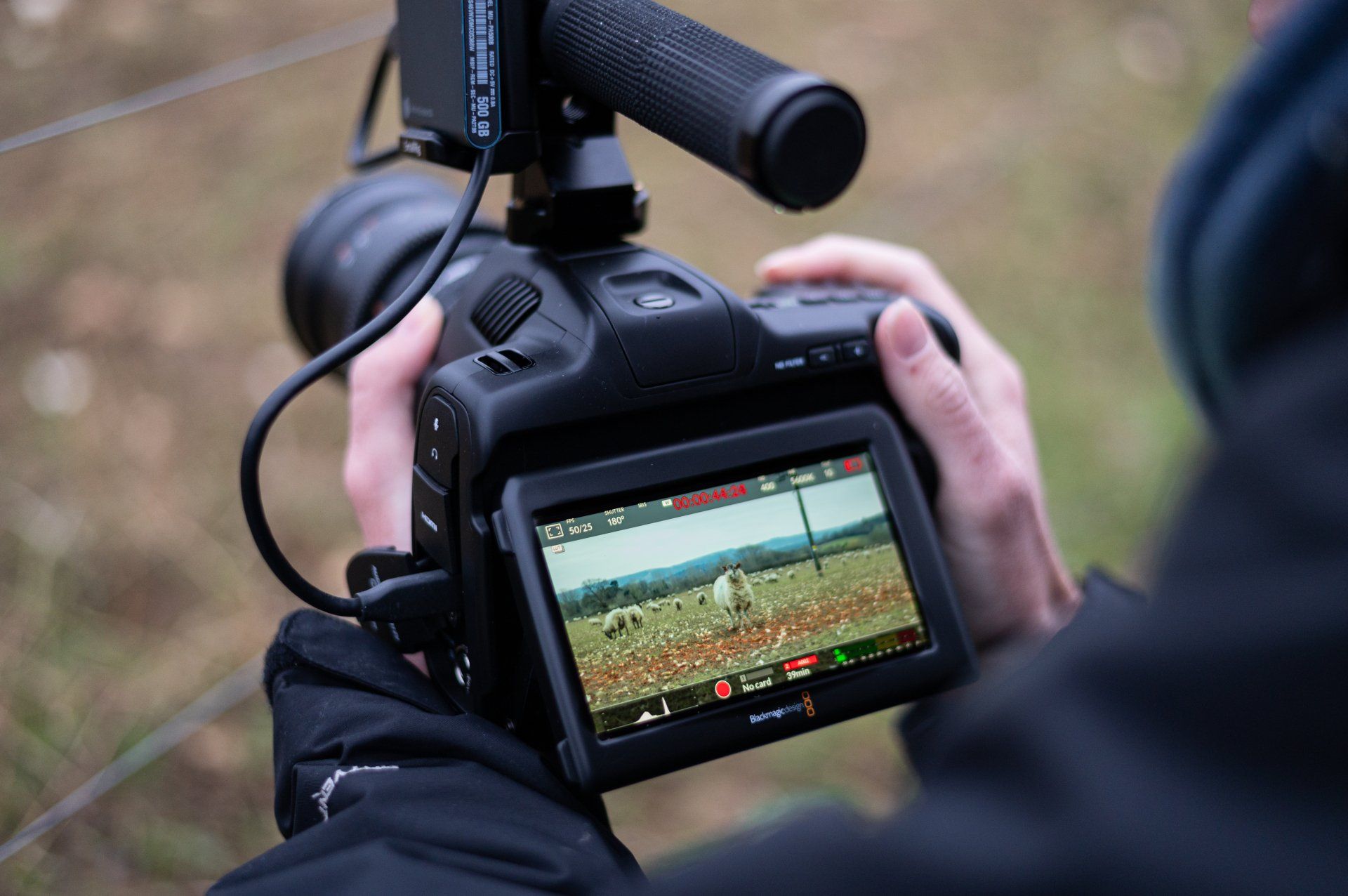 A person is holding a camera with a microphone attached to it.