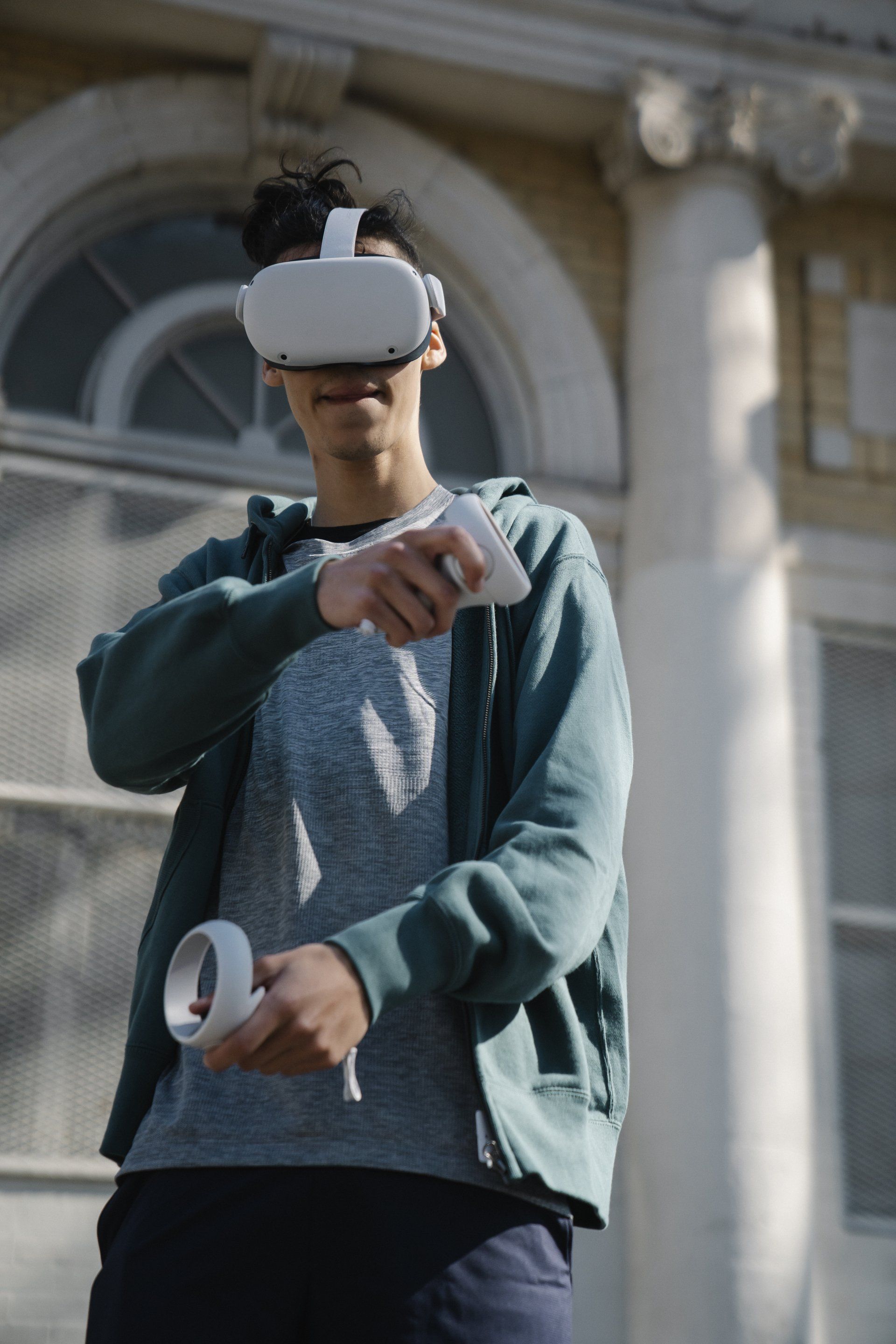 A man is wearing a virtual reality headset and holding a controller.