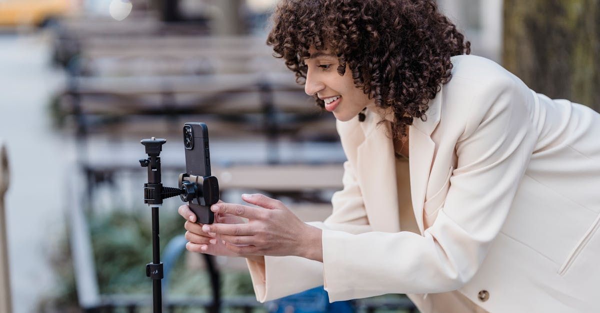 A woman is taking a picture with her phone on a tripod.