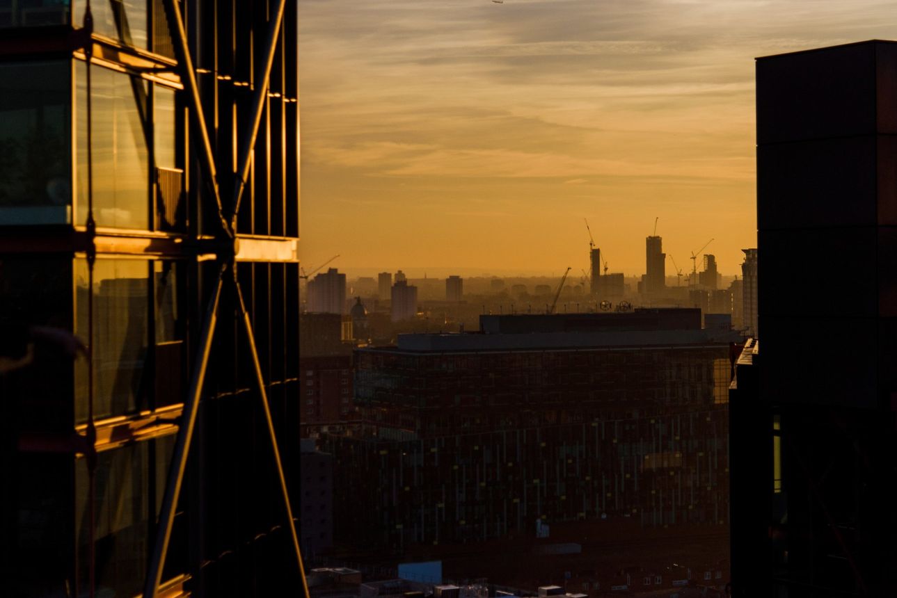 A sunset over a city with a building in the foreground