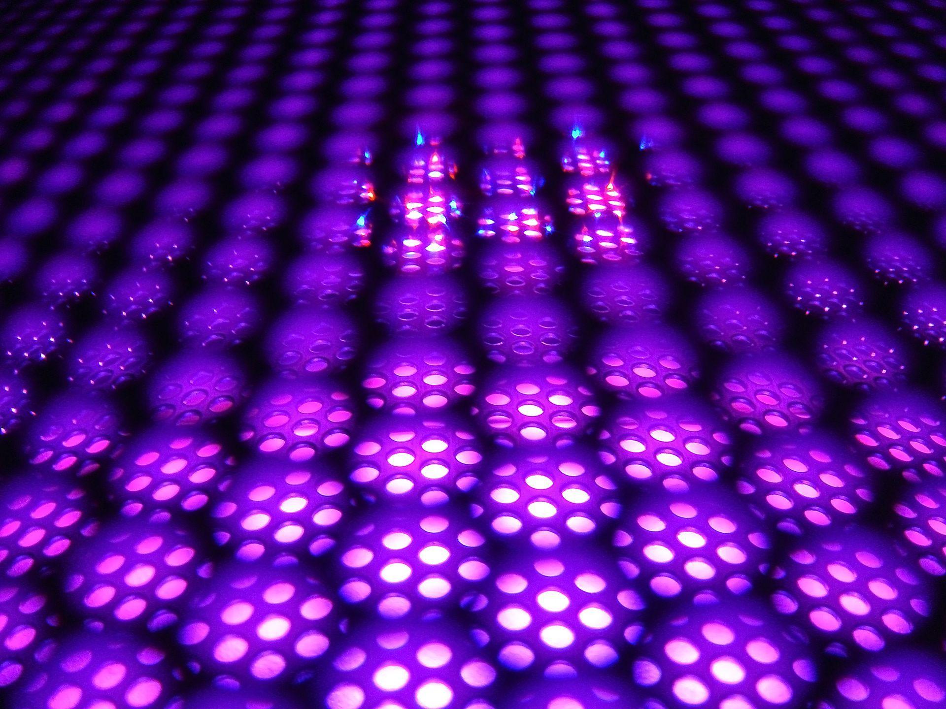 Purple lights are shining on a black surface