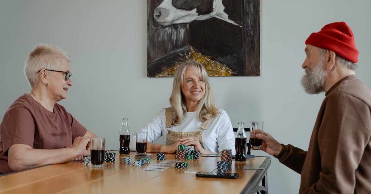 a group of people are sitting at a table playing a game of poker .