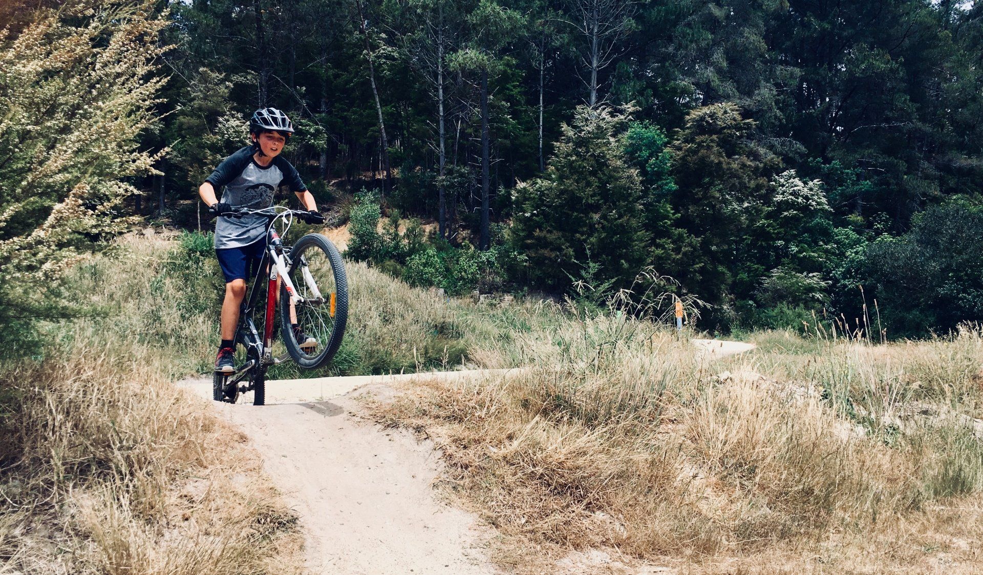 A person is riding a bike down a dirt path.