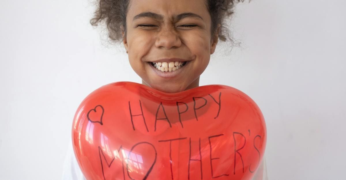 Girl holding a red heart-shaped balloon that reads