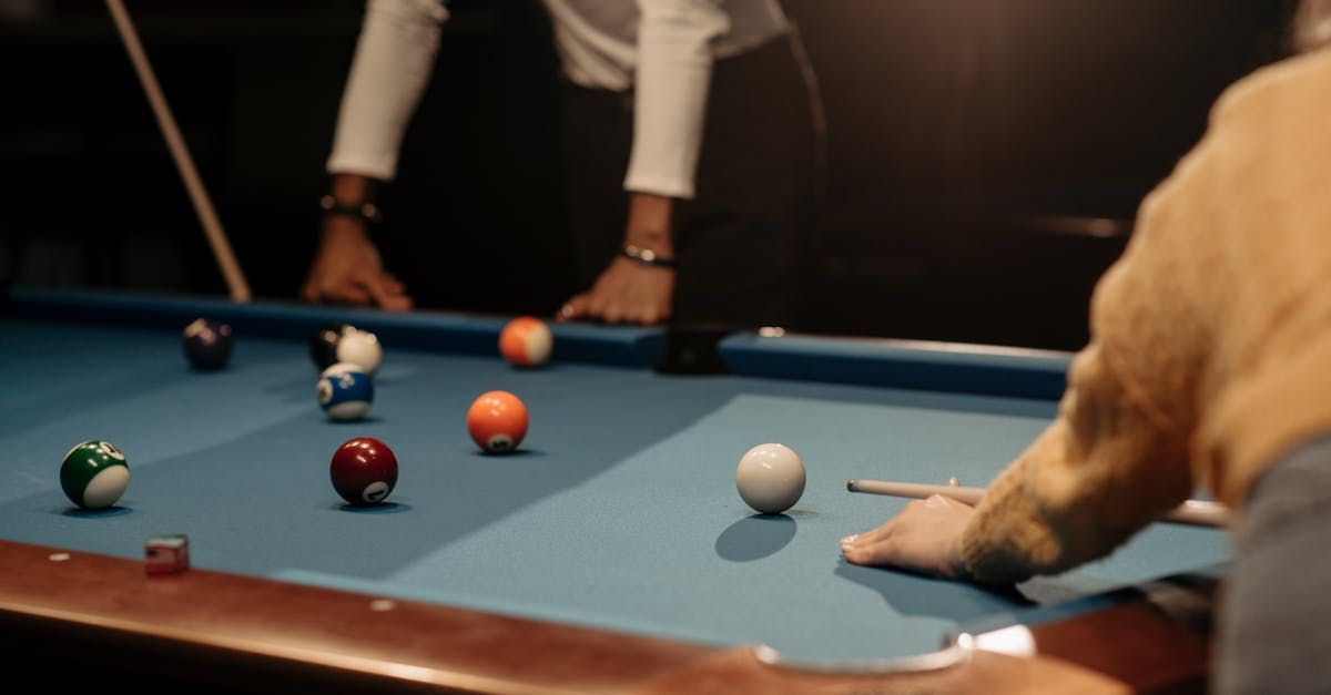 a man is playing pool with a cue on a pool table .