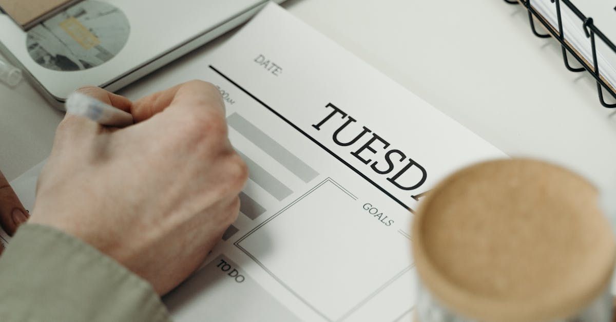 A person is writing on a piece of paper that says tuesday.