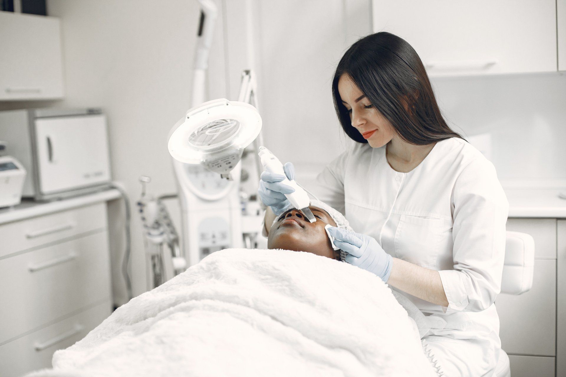 A woman is giving a man a facial treatment in a beauty salon.