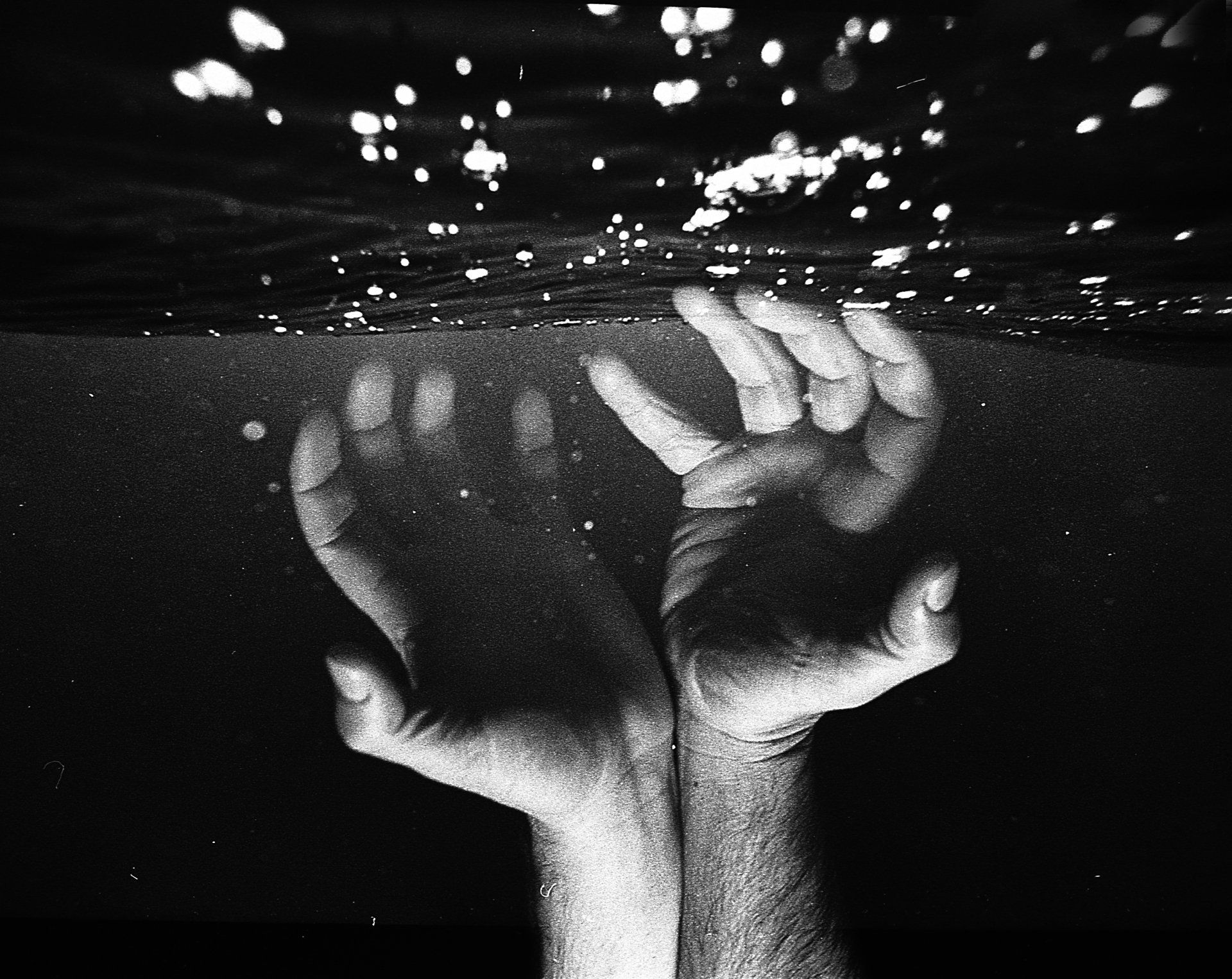 une photo en noir et blanc des mains d' un artiste sous l' eau
