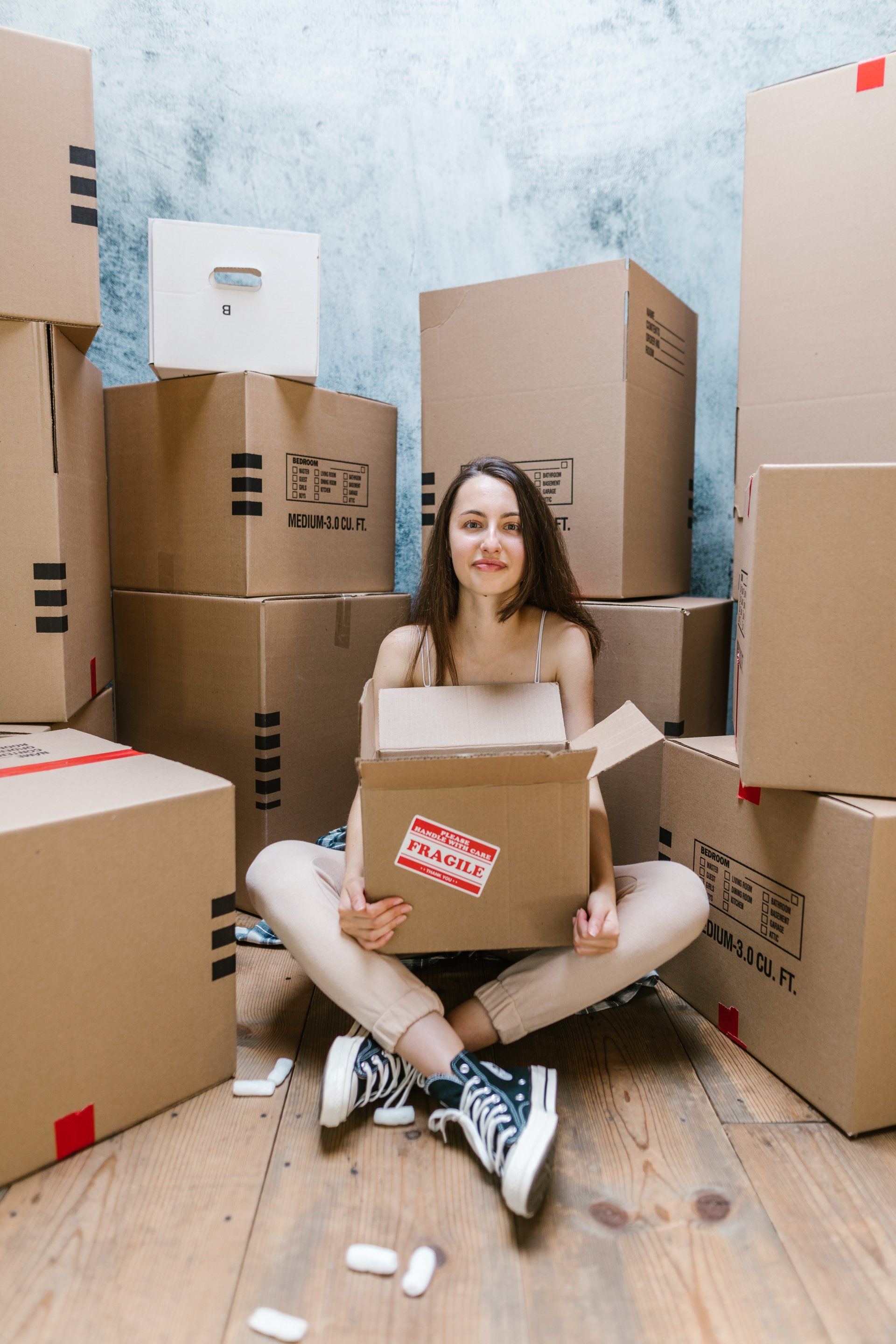 a woman sits around stacked moving cartons