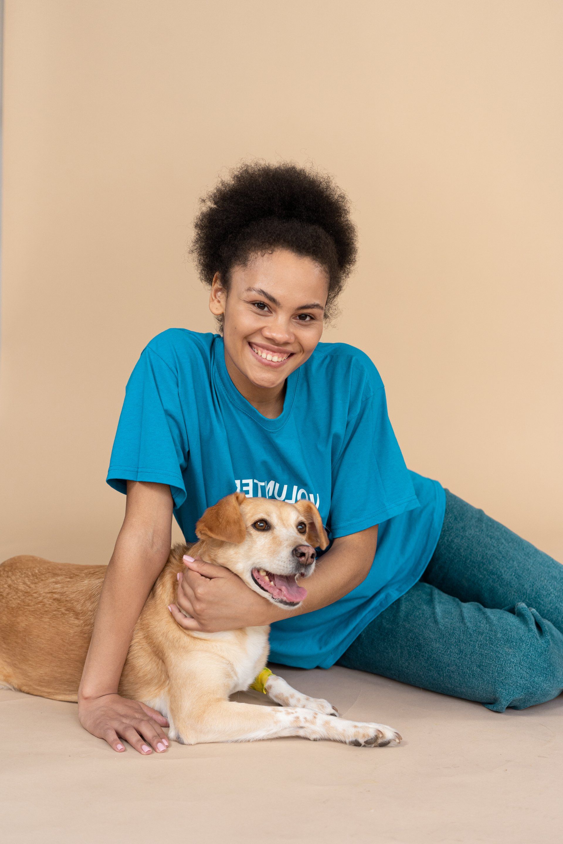 a woman is sitting on the floor holding a dog .