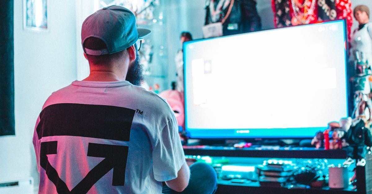 A man is sitting in front of a computer monitor.