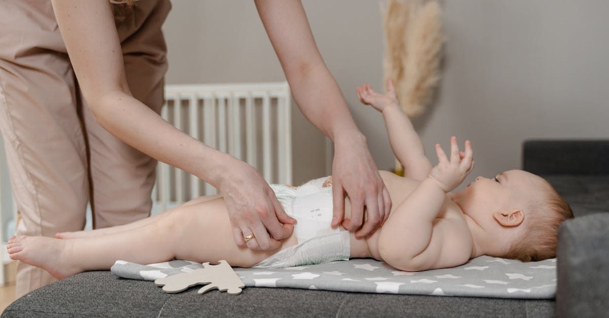 A pregnant woman is sitting on the floor in a lotus position holding her belly.