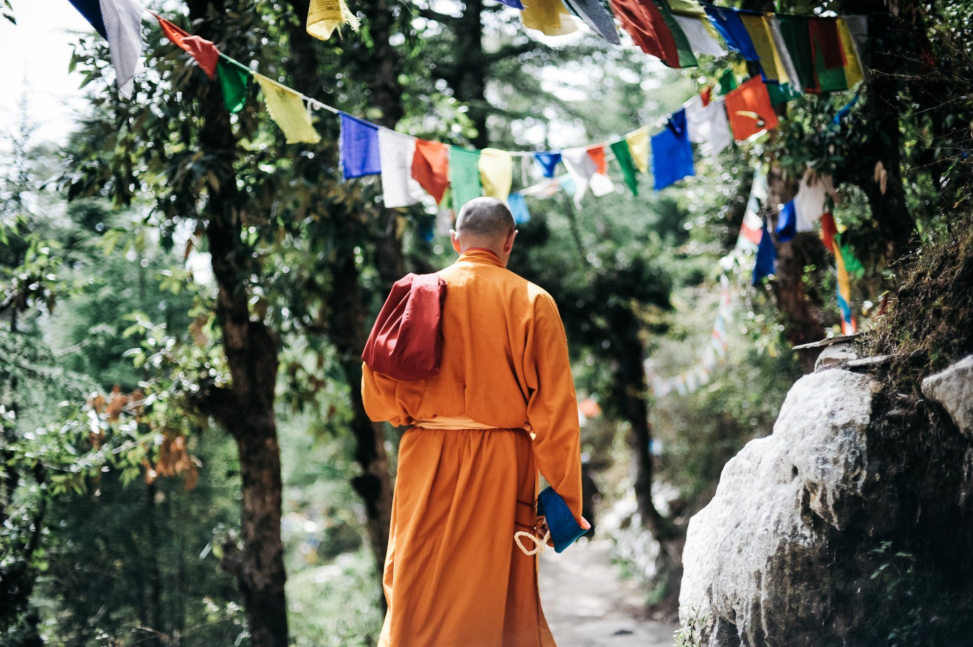 prayer flags Tibetan monk on path