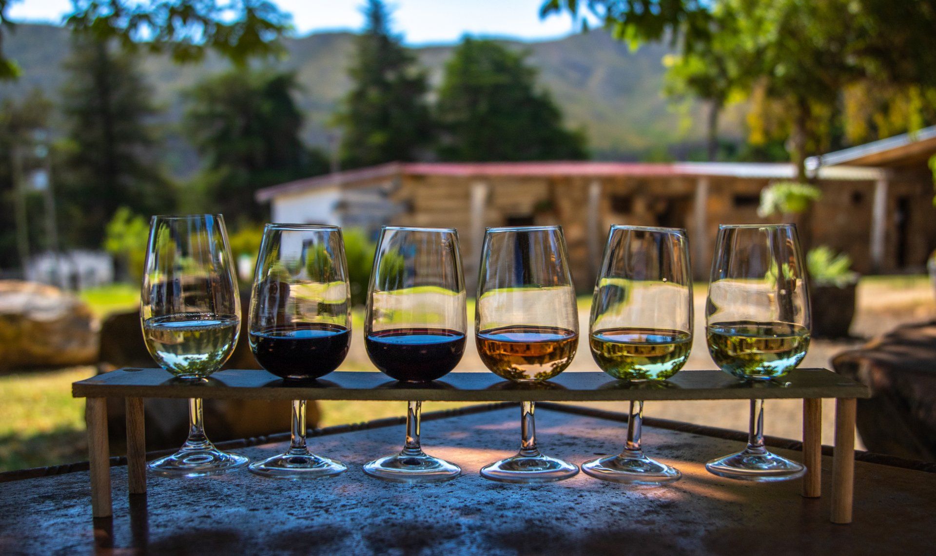 A row of wine glasses sitting on top of a wooden table.